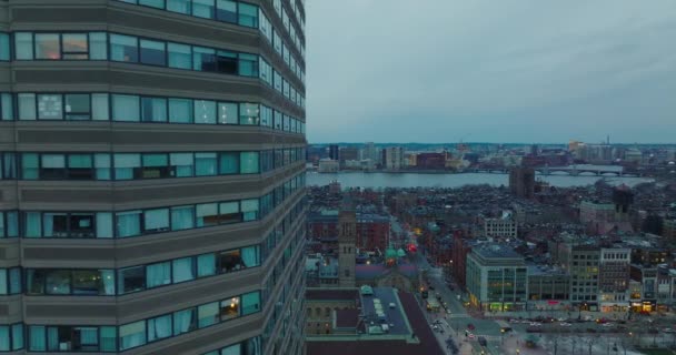 Windows of high rise office tower. Sliding reveal of residential neighbourhood and wide Charles river at dusk. Boston, USA — Vídeo de stock