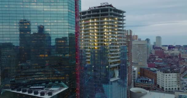 Prezentacja materiału filmowego z budowy nowego, wysokiego budynku. Otaczające wieżowce odzwierciedlające inne budynki w błyszczącej szklanej fasadzie. Boston, USA — Wideo stockowe