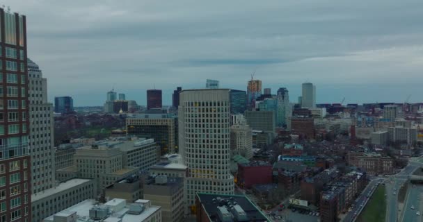 Backwards reveal of buildings in wider downtown. Aerial view of high rise office buildings and busy highway at dusk. Boston, USA — Vídeo de stock