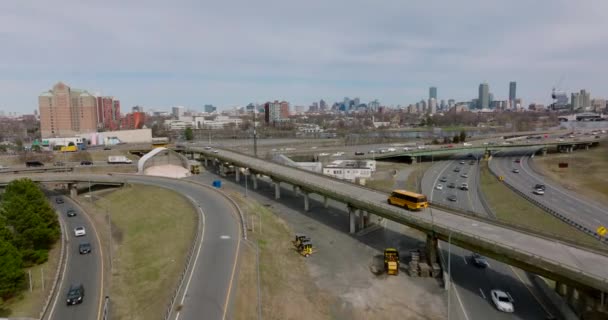 Tracking of yellow school bus passing on long elevated exit ramp of road interchange in city. Boston, USA — Video