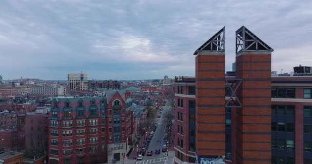 Vpřed létají nad bytovými domy s červenými cihlovými fasádami v obytném městském obvodu. Letecký záznam za soumraku. Boston, USA — Stock video