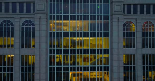 夕暮れ時に高層商業ビルのライトアップされたインテリアのバックショットを引く。周辺のダウンタウンのオフィスビルの後方を明らかにする。ボストン,アメリカ — ストック動画