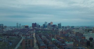 Kentsel çevredeki binaların üzerinden uçuyor. Limanda yolda giden araçlar. Şehir merkezindeki iş kuleleri. Boston, ABD