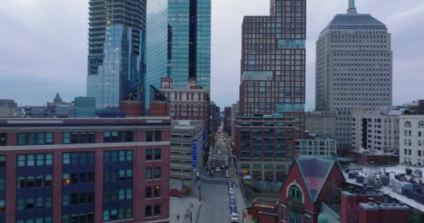 Latać nad ulicą w mieście. Wstecz ujawniają wysokie budynki biurowe w centrum miasta i żuraw wieżowy na placu budowy. Boston, USA — Wideo stockowe
