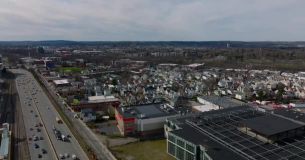 Flygfoto av bostadsområde vid upptagen motorväg. Rader av hus och lägenhetsbyggnader längs gatorna. Boston, USA — Stockvideo