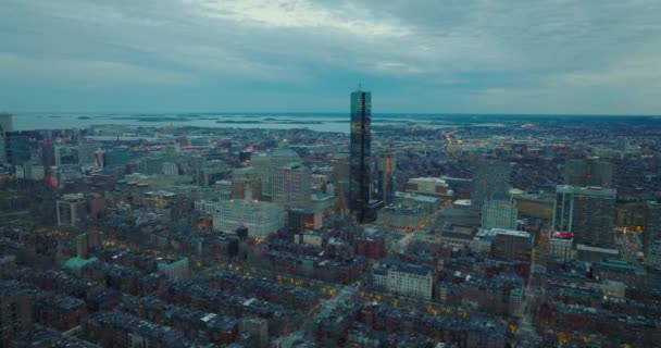 Letecký panoramatický záznam moderního vysokého mrakodrapu a okolních budov v centru. Večerní záběr velkého města. Boston, USA — Stock video