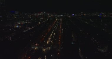 İleri, gece şehrinin üzerinde uçar. Sokak ışıklarıyla ve yanan ağaçlarla kaplı geniş düz bir cadde. Boston, ABD