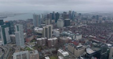 Arka planda şehir merkezinin ve su yüzeyinin hava panoramik görüntüleri var. Bulutlu bir günde şehir merkezindeki yüksek katlı ofis binaları. Boston, ABD