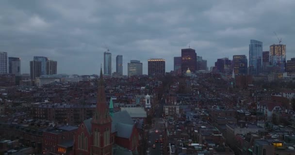 Aerial descending footage of residential urban neighbourhood at twilight. Modern high rise office buildings in background. Boston, USA — 비디오