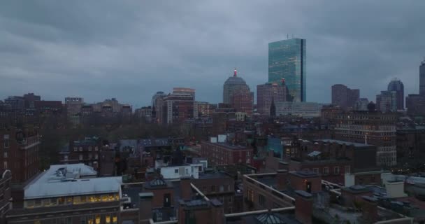 Vorwärts fliegen über gemauerte Wohnhäuser in einem Wohnviertel. Moderne Bürohochhäuser im Hintergrund. Stadt in der Dämmerung. Boston, USA — Stockvideo