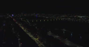 Gece sinematik şehir manzarası çekimleri. Uzun nehre giden yoldaki trafiğin hava görüntüsü. Sokak ışıkları ve renkli aydınlatma karanlığa doğru parlıyor. Boston, ABD