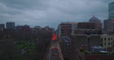 Alacakaranlıkta şehir merkezinde trafik vardı. Trafik ışıklarının önündeki sıra sıra fren lambaları. Forvetler halka açık park boyunca uçar. Boston, ABD