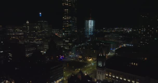 Backwards reveal of high rise buildings in city centre. Fly above urban borough at night. Boston, USA — Stock Video