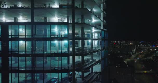 Nedstigning skott längs ljust upplyst byggarbetsplats av moderna höghus på natten. Boston, USA — Stockvideo