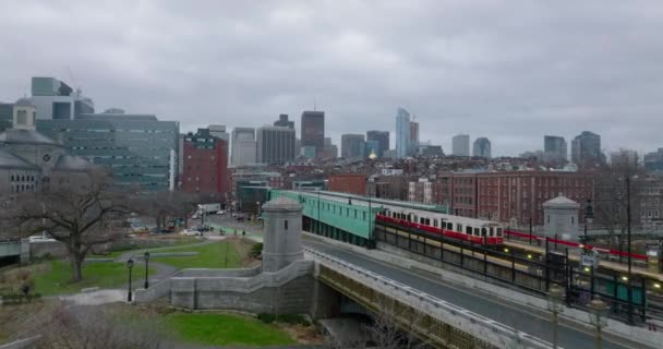 Forwards fly along train stop in city. Subway units driving on overground track on cloudy day. Boston, USA — ストック動画