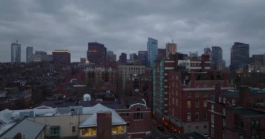 Back Bay borough ve şehir merkezindeki tuğla binalar alacakaranlıkta bulutlu gökyüzüne karşı yükseliyor. Boston, ABD