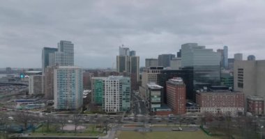 Şehir merkezindeki yüksek binaların havadan yükselen görüntüleri. Çok şeritli yollar dolanıyor. Boston, ABD