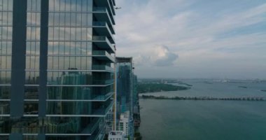 İleriye doğru rıhtımdaki fütüristik konut kulesi boyunca uçar. Çevredeki binalar açığa çıkıyor. Miami, ABD