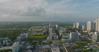 Wynwood ilçesindeki binaların havadan görünüşü. Günbatımı ile aydınlatılan modern gökdelenler. Miami, ABD