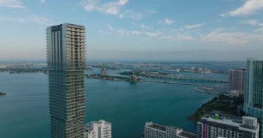 Alacakaranlıkta rıhtımdaki yüksek binaların üzerinden uç. Köprülerin ve adaların havadan görünüşü. Miami, ABD