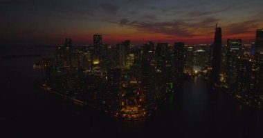 Rıhtımdaki binanın hava panoramik görüntüleri. Aydınlatılmış sokaklar ve aydınlık pencereler modern yüksek katlı apartmanların geceleri. Miami, ABD