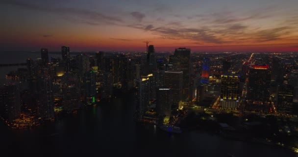 Espectacular metraje panorámico de la ciudad contra el colorido cielo crepuscular. Vista aérea de las siluetas de rascacielos del centro. Miami, Estados Unidos — Vídeos de Stock