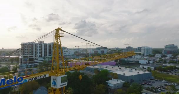 Stram flygning runt tornkranen och avslöjande utsikt över byggnader i stadsdelen vid skymningen. Miami, USA — Stockvideo