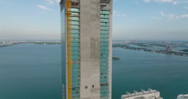 Yeni modern gökdelen şantiyesinin yörüngesinde çekildi. Arka planda su yüzeyi ve ada var. Miami, ABD