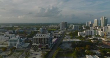 Çağdaş kentsel kentin üzerinde altın saatte ileri uçar. Binalar parlak, alçak güneşle aydınlatılıyor. Miami, ABD