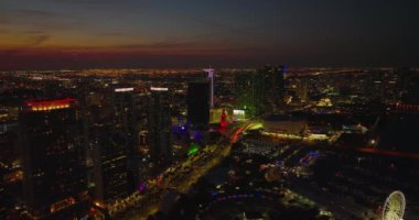 Gece şehrinin üzerinde uç. Modern yüksek binaların ve düz arazideki büyük yerleşim yerlerinin etrafındaki işlek sokaklar. Miami, ABD
