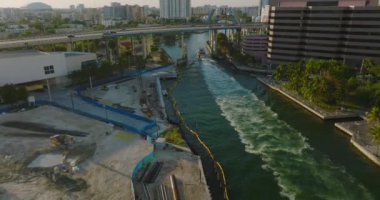 Modern şehirde otoyol köprüsünün altından geçen geminin izini sürüyorum. Sahne öğleden sonra güneşiyle aydınlandı. Miami, ABD