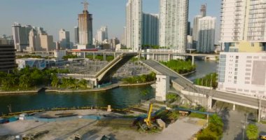 Şehirdeki nehirde tekne sürüyor, çift yapraklı Bascule yol köprüsünün altından geçiyor. Sahne batan güneşle aydınlatıldı. Miami, ABD