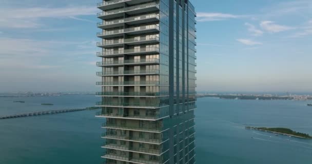 Orbite autour des immeubles modernes de grande hauteur avec façade brillante. Grande tour résidentielle sur le front de mer au crépuscule. Miami, États-Unis — Video