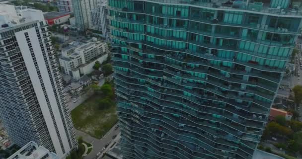 Adelante vuelan alrededor del moderno edificio de apartamentos de lujo de gran altura. revelando casas en el barrio residencial. Miami, Estados Unidos — Vídeo de stock