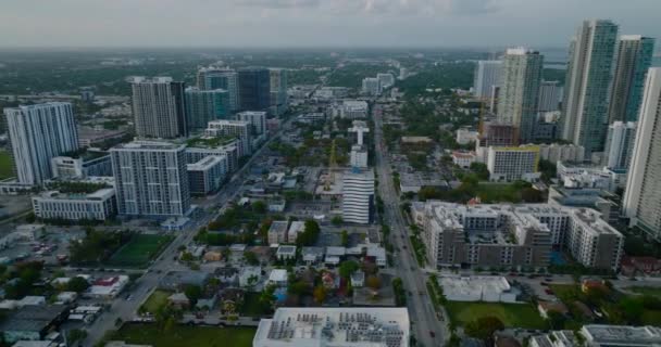 Vista aérea de edifícios em borough urbano após o por do sol. Tráfego intenso em ruas com múltiplas faixas. Miami, EUA — Vídeo de Stock