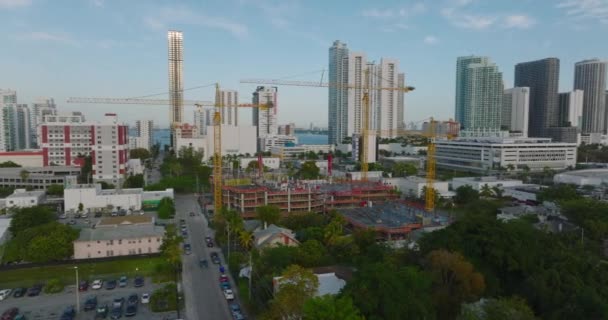 Snímek a pánev skupiny věžových jeřábů na staveništi nové moderní výškové budovy. Miami, USA — Stock video