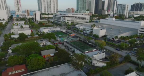 Liten fotbollsplan i staden i tropikerna. Spelare som har match i inhägnat område i modern stad. Miami, USA — Stockvideo