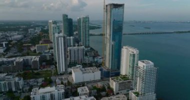 Rıhtımdaki yüksek apartmanların kayma ve pan görüntüleri. Gün batımından sonra hava manzarası. Miami, ABD