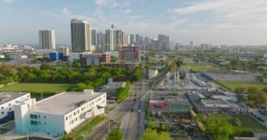 Büyük şehrin havadan panoramik görüntüsü. Yoldan geçen ve raylardan geçen araçlar. Arka planda yüksek katlı apartmanlar var. Miami, ABD