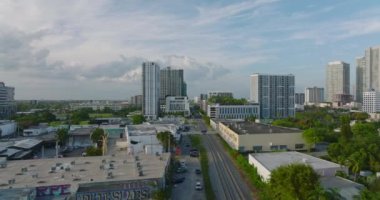 Şehirdeki yeşil bitki örtüsünün ve binaların manzarası yükseldi. Yoldan geçen ve raylardan geçen araçlar. Miami, ABD
