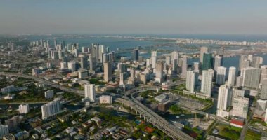 Modern kentsel kentin hava panoramik görüntüleri, sahil boyunca yüksek binalar ve altın saatinde yoğun ulaşım altyapısı. Miami, ABD