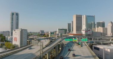 İleri uçaklar çok katlı ve çok şeritli otoyol kavşağının üzerinde uçuyor. Yüksek binalar arasında yoğun trafik var. Miami, ABD