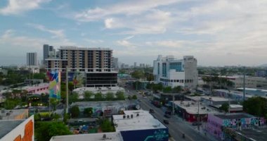 İleri uçaklar şehir merkezinin üzerinde. Sanatsal kent semtindeki sokaklar boyunca çeşitli binalar. Miami, ABD