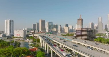 Çok şeritli otoyolda giden arabalar. Arka planda modern apartman binaları var. Miami, ABD