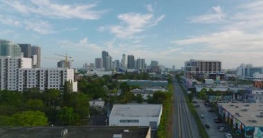 İleri uçaklar şehir merkezinin üstünde, yüksek katlı apartmanlar da arka planda. Demiryolu şehire doğru gidiyor. Miami, ABD