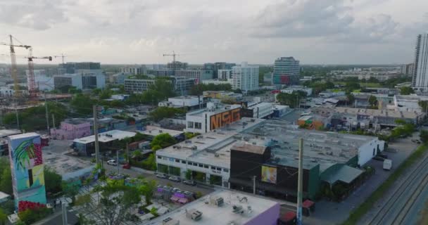 Fly above large city at twilight. Commercial buildings along streets in urban neighbourhood. Miami, USA — Stock Video