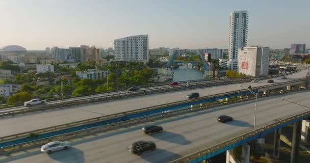 Передній політ над багатосмуговим шосе в місті. Викриття розкішної яхти, що проходить по річці і направляється на піднятий міст. Маямі (США) — стокове відео