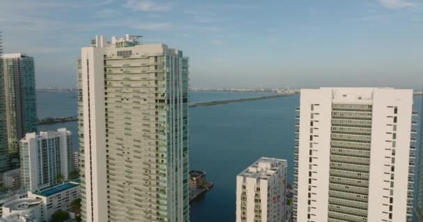 Вперед летят над высокими многоквартирными домами на набережной. Дорога и мост ведут в Майами-Бич. Майами, США — стоковое видео
