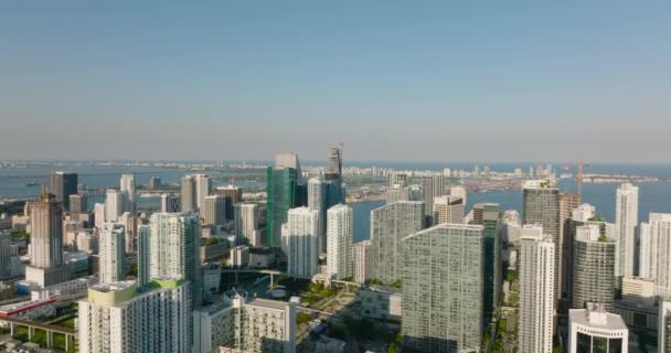 Yüksek katlı apartmanların modern yerleşim kompleksinin havadan yükselen görüntüleri, arka plandaki su yüzeyi. Miami, ABD — Stok video