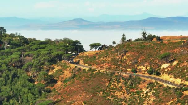 田舎の道路を通過する車のスライドやパンの映像 山の尾根や霧の背景に谷が殺到した 南アフリカ共和国ケープタウン — ストック動画